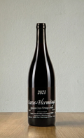Wine bottle labeled '2021 Crozes-Hermitage' on a wooden surface with a white background